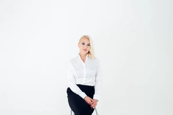 Πορτρέτο μιας ξανθιάς γυναίκα με ένα λευκό πουκάμισο και μαύρο παντελόνι — Φωτογραφία Αρχείου