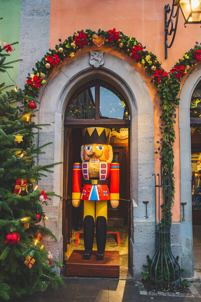 A shop window decorated with the Nutcracker figure, Christmas tree, and the garlands for Christmas holidays in a german town. The town is a well known destination for tourists from around the world