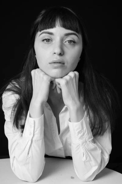 Studio Portrét Krásné Brunetky Bílé Košili Sedí Stolu Prostém Černém — Stock fotografie