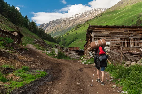 Man with backpack goes up in Caucasus Mountains