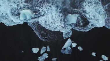 İHA 'nın üst görüntüsü, İzlanda' da kara plaja dalga çarpması.