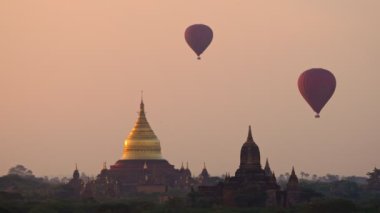 Güneş doğarken Bagan ovasının üzerinde sıcak hava balonu, Myanmar
