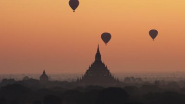 Güneş doğarken Bagan ovasının üzerinde sıcak hava balonu, Myanmar