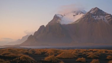 Mt. Günbatımında siyah kum tepeleri olan Vestrahorn, Stoksnes, İzlanda