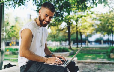 Wifi için bağlı bir dizüstü bilgisayarda web sörf hipster adam sakallı 