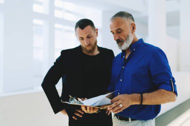 Yeni tartışırken akıllı rahat kıyafetler giymiş iki iş adamları ayrıntıları parlak office koridorda duran proje. Yorum onun çalışan Pazar rapor veren satış müdürü.