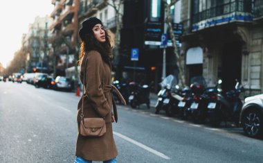 Büyüleyici uluslararası öğrenci kız akşam şehrin yürürken yol geçtikten trendy kıyafetler giyiyor. Sonbahar tatil sırasında yeni şehir manzaraları keşfetmek turist kadın.