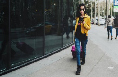 Asya'dan gelen başarılı tasarımcı, bavuluyla birlikte taksiye doğru giderken cep telefonuyla acil e-postaları yanıtlarken bir kenara bekliyor. Öğrenci kız onu yaklaşan tatil sosyal medyada bilgi paylaşımı