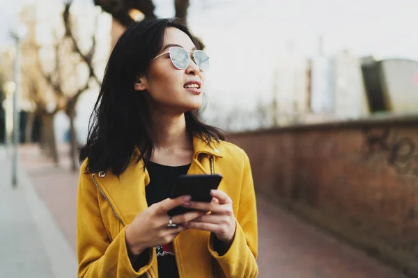 Красивая Азиатская Студентка Смотрит Сторону Идя Улице Мобильным Телефоном Руках — стоковое фото