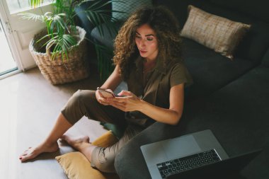 Girişimci kadın bir cep telefonuyla banka hesabını kontrol ediyor. Çevrimiçi alışveriş yapan çekici bir kadın kendini izole ederken evde otururken akıllı telefon kullanıyor. Başarılı tasarımcı e- postaları okuyor.