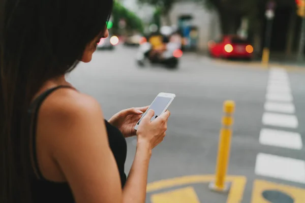 Arka Planda Sokakta Yürürken Cep Telefonuyla Mesajlaşan Esmer Bir Kadının Stok Resim