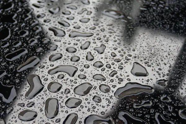 Gotas de lluvia sobre fondo de superficie oscura — Foto de Stock