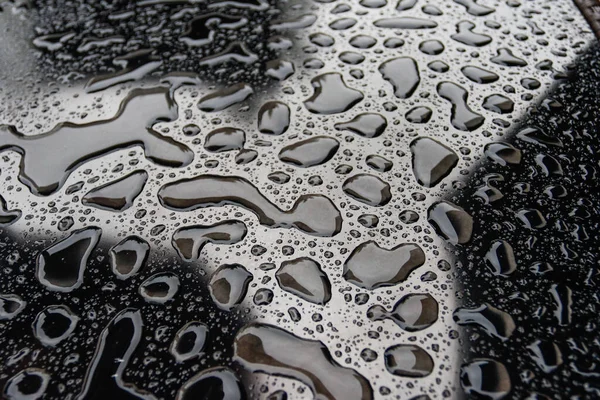 Gotas de lluvia sobre fondo de superficie oscura — Foto de Stock