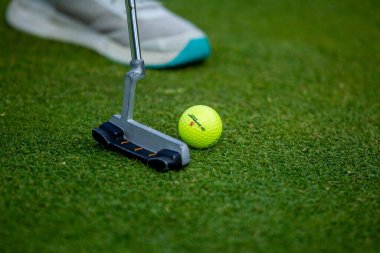 Golf sopası, golf topu, yeşil delikte şömine.