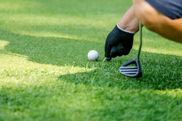 Golfista marca a bola durante o torneio joga com o clube em campo — Fotografia de Stock