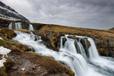 Amazing Icelandic landscape at the top of Kirkjufellsfoss waterfall with Kirkjufell mountain in the background on the north coast of Iceland Snaefellsnes peninsula clipart