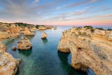 Şaşırtıcı günbatımı Marinha Beach deki Algarve, Portekiz. Avrupa'nın ana tatil yerlerinden biri güçlü renkleri ile manzara. Yaz turistik.