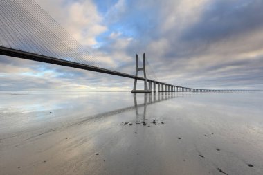 Vasco da Gama Köprüsü manzarası gün doğumunda. Dünyanın en uzun köprülerinden birisidir. Lizbon muhteşem bir turistik yerdir çünkü ışığı, anıtları vardır. Portekiz tarihi.