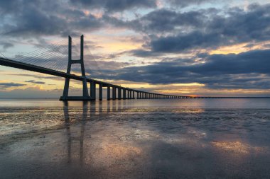 Vasco da Gama Köprüsü manzarası gün doğumunda. Dünyanın en uzun köprülerinden birisidir. Lizbon muhteşem bir turistik yerdir çünkü ışığı, anıtları vardır. Portekiz tarihi.