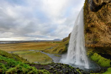 Görkemli Seljalandsfoss, İzlanda'daki en ünlü şelale. Günbatımı manzara. Güzel turistik cazibe ana tatil yerlerinden biri. 