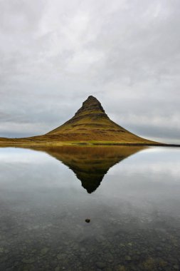 Kirkjufell dağın içinde belgili tanımlık geçmiş ile manzara. Kuzey Sahil İzlanda Snaefellsnes Yarımadası şaşırtıcı ayna efekti. Doğal seyahat hedef.