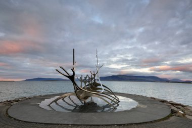 Icekand, Solfar at sunset. Sun Voyager monument, landmark of Reykjavik city with sea and mountains in background, Iceland clipart