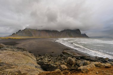 Büyülü manzara Vestrahorn dağlar ve gündoğumu, İzlanda'daki siyah kum tepeleri. Panoramik manzaralı bir Colorfulseascape Stokksnes burun.