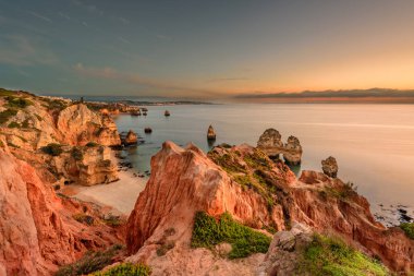 Amazing landscape at sunrise. Beautiful beach near Lagos in Ponta da Piedade, Algarve region, Portugal.  Seascape with Cciff rocks. clipart