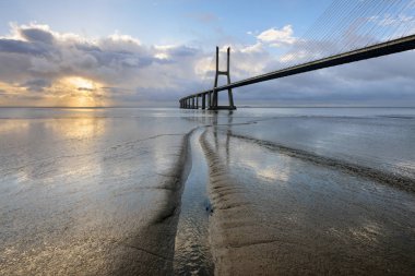 Vasco da Gama Köprüsü manzarası gün doğumunda. Dünyanın en uzun köprülerinden birisidir. Lizbon muhteşem bir turistik yerdir çünkü ışığı, anıtları vardır. Portekiz tarihi.