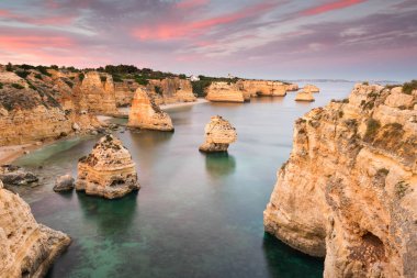 Şaşırtıcı günbatımı Marinha Beach deki Algarve, Portekiz. Avrupa'nın ana tatil yerlerinden biri güçlü renkleri ile manzara. Yaz turistik.