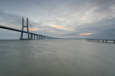 Kentsel peyzaj, gündoğumu. Lizbon şaşırtıcı bir turistik yer. Vasco da Gama Köprüsü güzel bir dönüm noktası ve dünyanın en uzun köprüleri biridir. Portekiz bir şafak ışık.