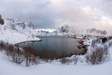 Norveç 'in Lofoten Adaları' ndaki güzel Reine köyü. Kar gün batımında kış manzarasını kapladı. Kutup çevresinde inanılmaz bir turistik cazibe var. Panoramik görünüm.