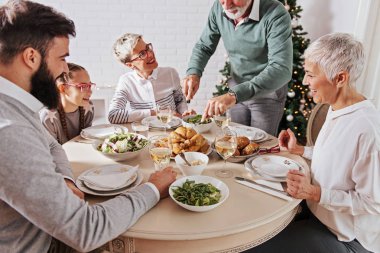 Aile üzerinde Noel tatili için toplanan kutluyor, öğle yemeği 