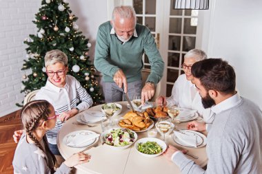 Aile üzerinde Noel tatili için toplanan kutluyor, öğle yemeği 