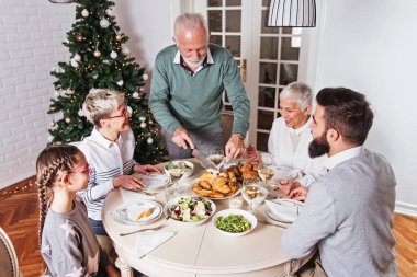 Aile üzerinde Noel tatili için toplanan kutluyor, öğle yemeği 