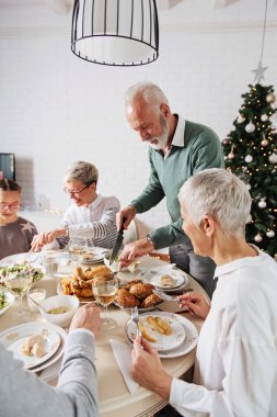 Aile üzerinde Noel tatili için toplanan kutluyor, öğle yemeği 