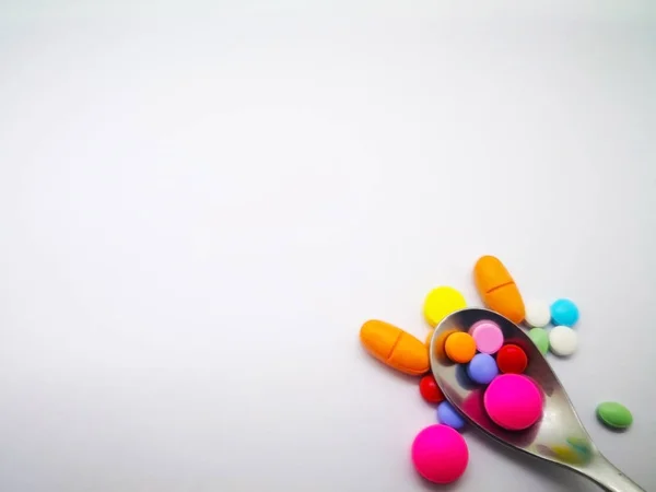 药物和医疗保健的概念 许多五颜六色的药片 那是在银勺 在白色背景 选择性焦点和复制空间上被隔离 — 图库照片