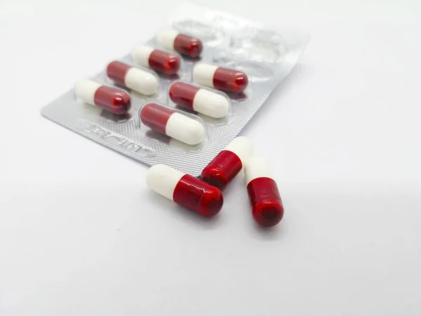 İlaç kavramı. Birçok beyaz-kırmızı beyaz arka plan üzerinde izole Gemfibrozil 300 mg kapsül, cholesteral ve kandaki trigliserid azaltmak için yardımcı olur. Ön plan ve kopya alanı üzerinde odaklanmak.