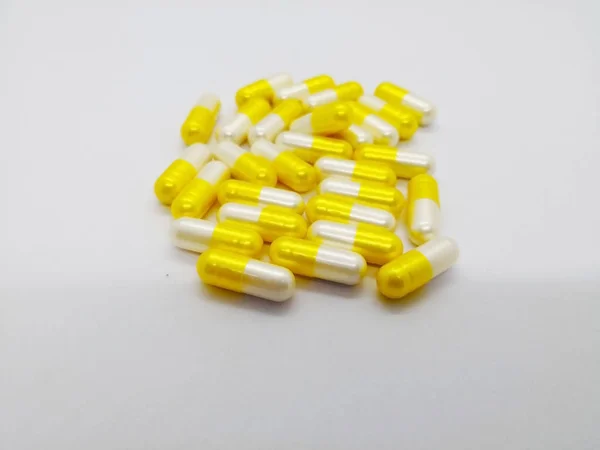 Tıbbi ve sağlık kavramı. Tranexamic asit 250 mg. (menstruasyon) aylık dönemlerde ağır kanama tedavisinde kullanılan beyaz zemin üzerine izole birçok beyaz-sarı kapsül. Ön plan ve kopya alanı üzerinde odaklanmak.