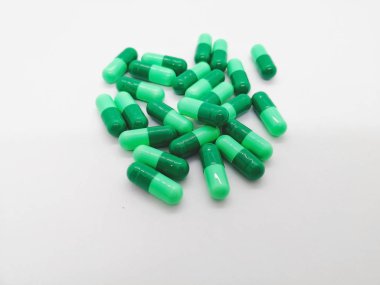İlaç ve sağlık kavramı. Sefaleksin 500 mg. bakterilerin neden olduğu ciddi enfeksiyonların tedavisinde kullanılan beyaz zemin üzerine izole birçok yeşil kapsül. Seçici odak ve kopya alanı.