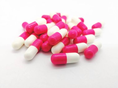 İlaç ve sağlık kavramı. Amoksisilin 250 mg. farklı türlerde bakterilerin neden olduğu enfeksiyon tedavisinde kullanılan beyaz zemin üzerine izole birçok beyaz-pembe kapsül. Seçici odak ve kopya alanı.
