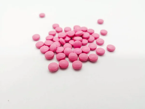 İlaç ve sağlık kavramı. Çok pembe tablet Aspirin 81 mg. tedavi etmek ya da kalp krizi, felç ve göğüs ağrısı (angina) önlemek için kullanılan, beyaz arka plan üzerinde izole yuvarlak. Seçici odak ve kopya alanı.