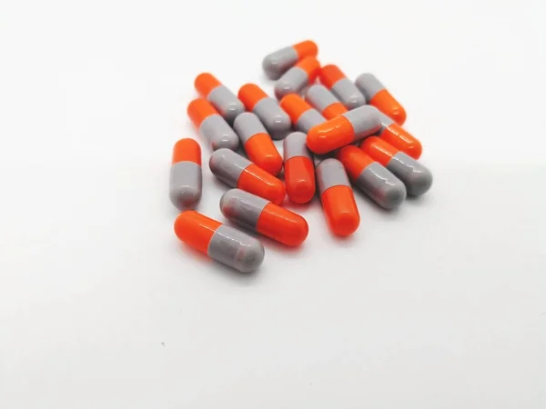 İlaç ve sağlık kavramı. Sefaleksin 250 mg. bakterilerin neden olduğu enfeksiyonların tedavisinde kullanılan beyaz zemin üzerine izole birçok gri-turuncu kapsül. Ön plan ve kopya alanı üzerinde odaklanmak.