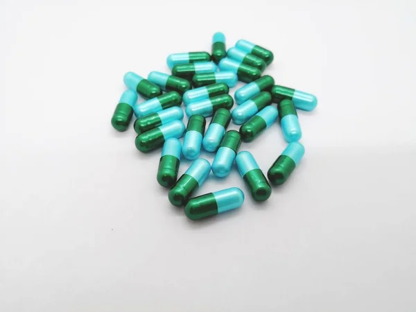 İlaç ve sağlık kavramı. Amoksisilin 500 mg. farklı türlerde bakterilerin neden olduğu enfeksiyon tedavisinde kullanılan beyaz zemin üzerine izole birçok yeşil-mavi kapsül. Ön plan ve kopya alanı üzerinde odaklanmak.