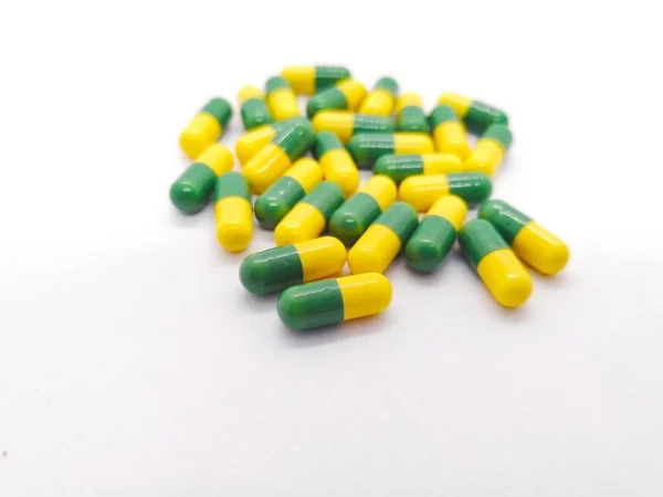 İlaç kavramı. Çok sayıda sarı-yeşil kapsül Tramadol 50 mg. orta şiddetli ağrı tedavisinde kullanılan beyaz arka plan üzerinde narkotik benzeri ağrı kesici, izole. Seçici odak ve kopya alanı. 