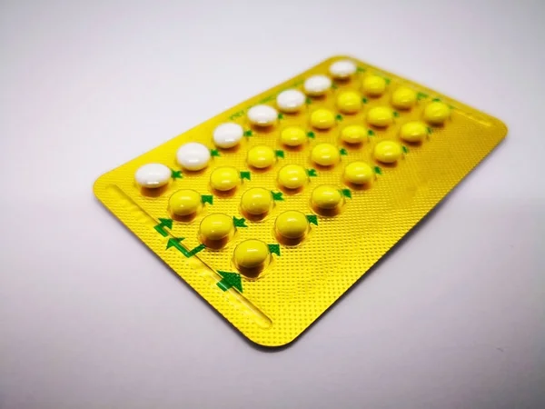 Oral contraceptive drug. 21 yellow pills consist of Ethinyl estradiol 0.035 mg. and Levonogestrel 0.15  mg. and 7 white pills placebo, for birth control. Abortion problem concept. Isolated on white background and selective focus.