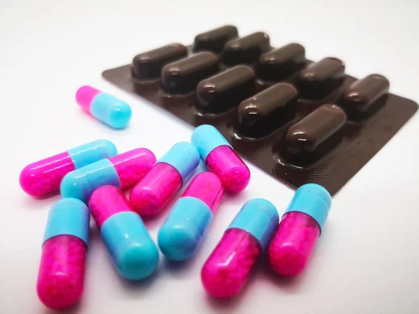 İlaç ve sağlık kavramı. İtrakonazol 100 mg akciğerler, ağız veya boğaz, ayak tırnaklarını veya tırnak gibi vücudun herhangi bir bölümünü istila edebilir mantar tarafından neden olduğu enfeksiyonların tedavisinde kullanılan., birçok pembe-mavi kapsül. Beyaz arka plan, sel