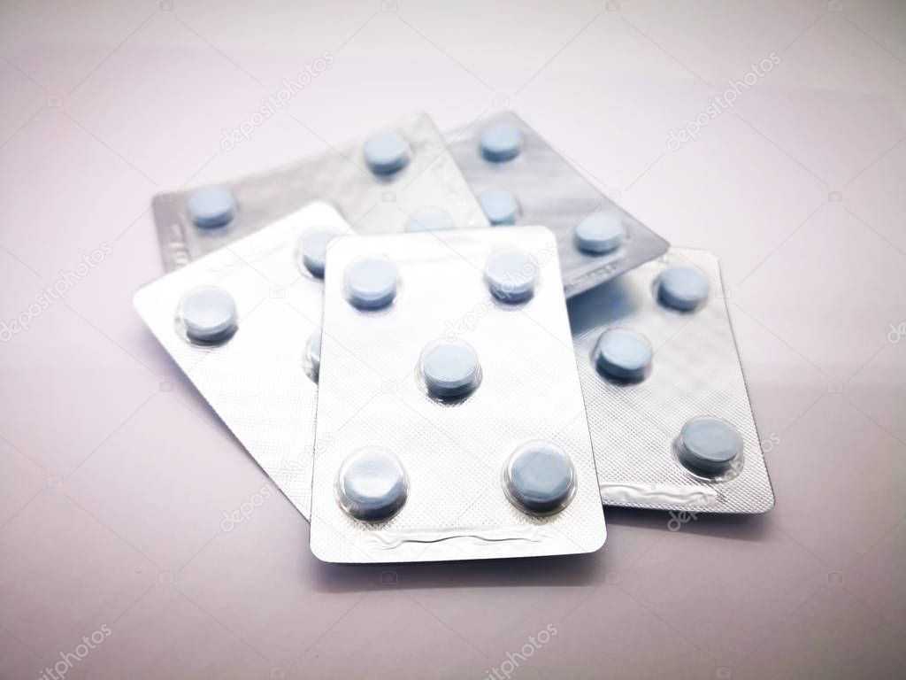 Medication, healthcare and sexual transmitted disease concept. Five pack of 200 mg. of Acyclovir blue tablets for full course treatment of herpes in child, such as genital herpes, cold sores, shingles, and chicken pox. Selective focus, isolated on wh