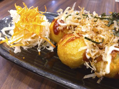 Bir Japon çerezim un, patatesten yapılan şal ahtapot parçalarını içeren küçük yuvarlak toplar şeklinde Takoyaki