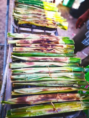 Yemek ve tatlı bir kavram. Karışık un, şeker, Hindistan cevizi sütü ve Hindistan cevizi et birlikte. Daha sonra Hindistan cevizi yaprakları ile sarılmış ve grillon için özgün kömür ocağı getir. Bu Tay tatlı 